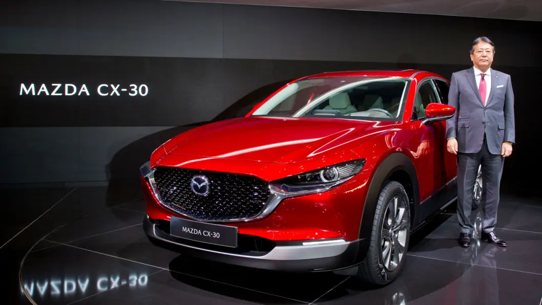 DESIGNBOMBE: Mazda lager lekre biler, og den kommende elbilen blir neppe noe unntak. Her er Mazda-sjef Akira Marumoto ved siden av nye CX-30-modellen under årets bilutstilling i Genève. Foto: Mazda DESIGNBOMBE: Mazda lager lekre biler, og den kommende elbilen blir neppe noe unntak. Her er Mazda-sjef Akira Marumoto ved siden av nye CX-30-modellen under årets bilutstilling i Genève. Foto: Mazda