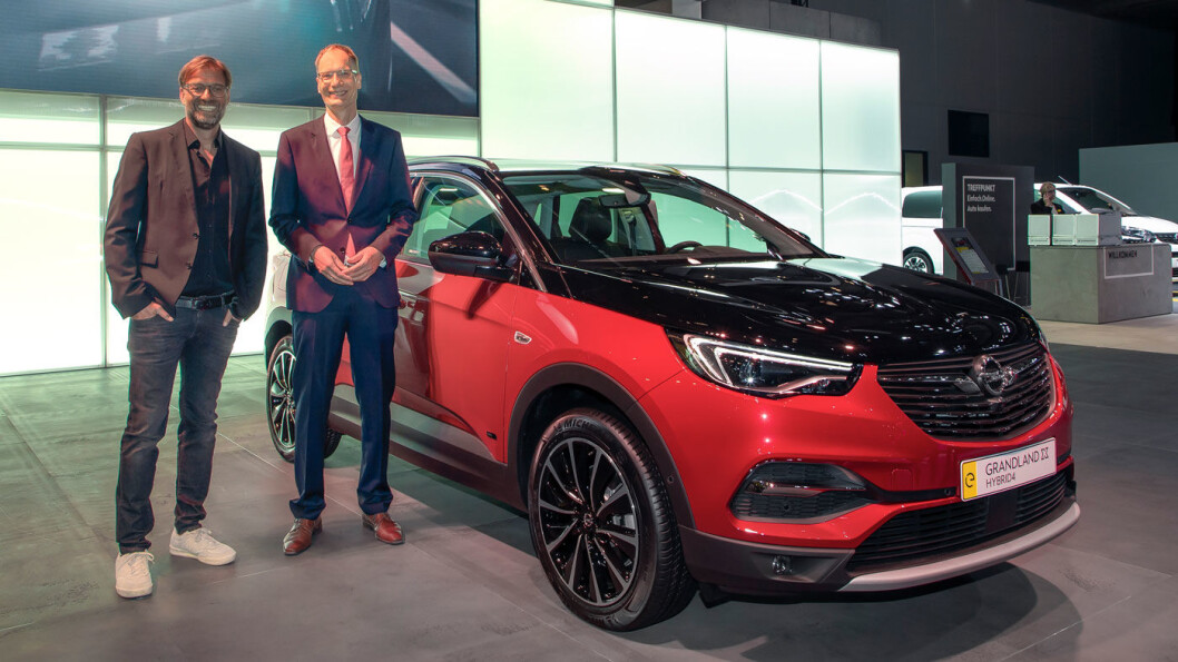 NÅ LADBAR: Liverpool-manager Jürgen Klopp smiler om kapp med Opel-sjef Michael Lohscheller ved siden av ladbare Opel Grandland X Hybrid. NÅ LADBAR: Liverpool-manager Jürgen Klopp smiler om kapp med Opel-sjef Michael Lohscheller ved siden av ladbare Opel Grandland X Hybrid.