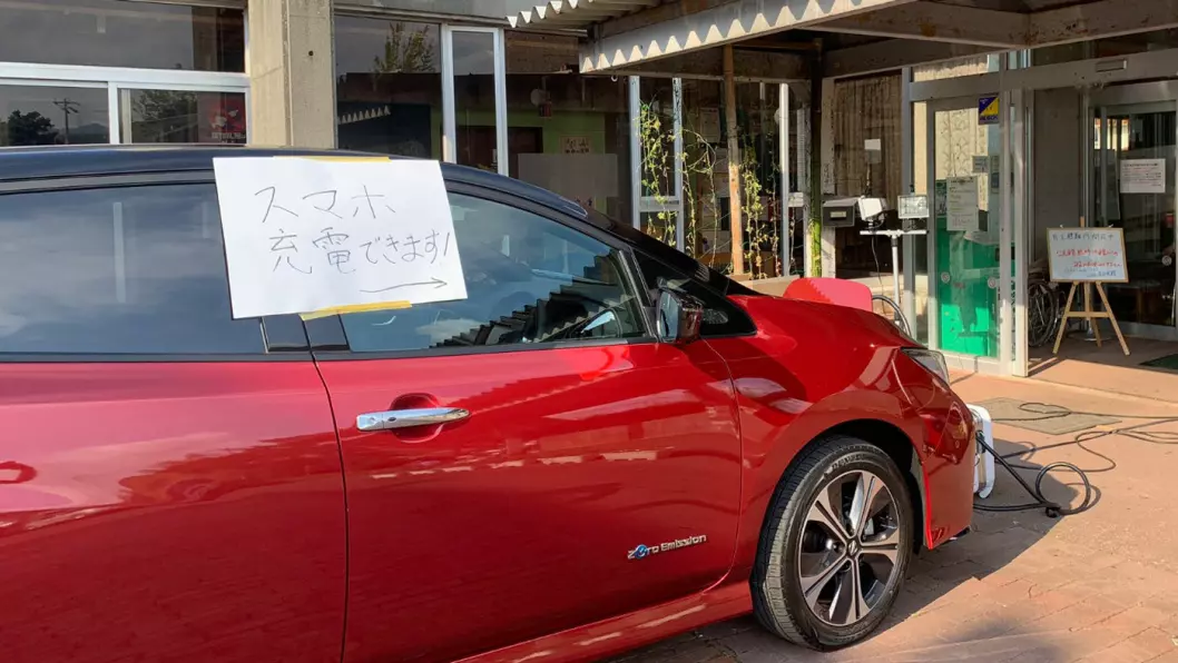 STRØMBANK: En Nissan Leaf oppstilt utenfor et kommunalt kontor i Chiba-prefekturet, med påskrevet beskjed om at man kan lade sine mobiltelefoner her. Foto: Nissan