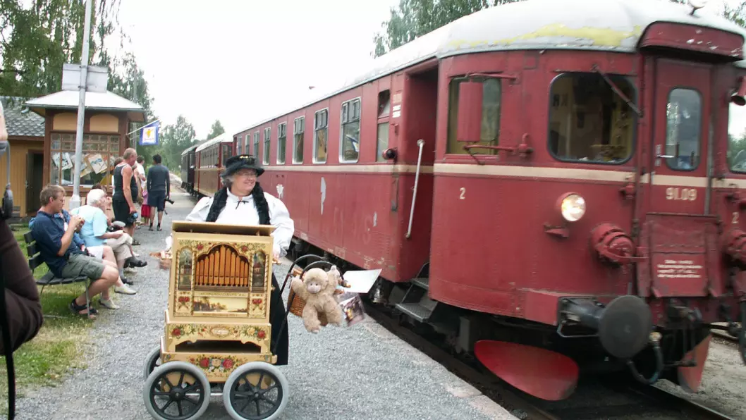 PAUSEMUSIKK: Torild med lirekassa mens toget tar en stopp på Krøderbanen.&nbsp;Foto: Privat