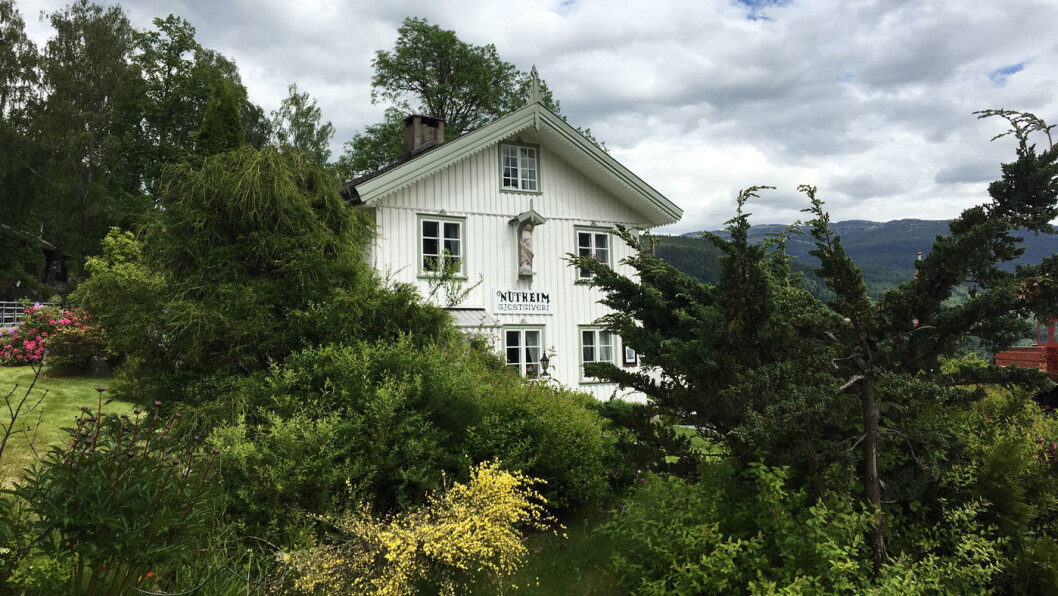 KUNSTNERHOTELLET: Nutheim gjestgiveri har vært skysstasjon siden 1877. Det hvite huset i den flotte hagen er en liten, fredet plett langs E134. KUNSTNERHOTELLET: Nutheim gjestgiveri har vært skysstasjon siden 1877. Det hvite huset i den flotte hagen er en liten, fredet plett langs E134.