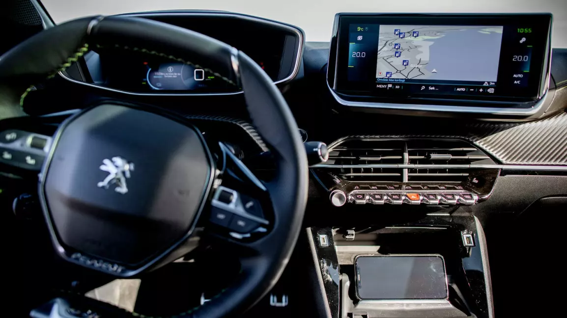 MOBILHOLDER: Mens bilen lader, kan du settet opp mobilen her og se på en film. Bak holderen er det ladeplate til mobilen – rimelig og nyttig ekstrautstyr.