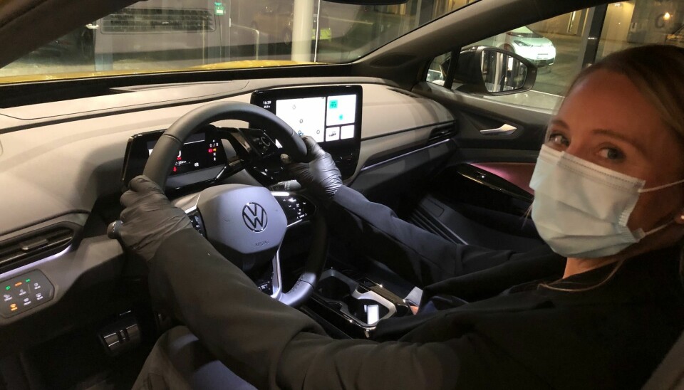 FORNØYD: Volkswagens kommunikasjonssjef Anita Svanes smiler bak munnbindet og rattet på en ID.4, som leveres ut til kundene i disse dager. Den mindre ID.3 har forhåpentligvis tatt støyten med barnesykdommene.