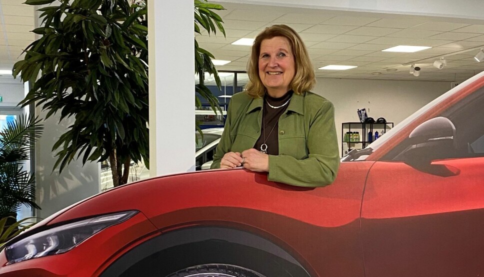 PAPIRBIL: Wenche Kristiansen Johre godtar Motors småtøysete idé om å fotografere henne med Ford-forhandlerens papp-utgave av Mustang Mach-E, mens hun venter på den ordentlige bilen hun har bestilt. I det minste er fargen, Rapid Red, den samme.