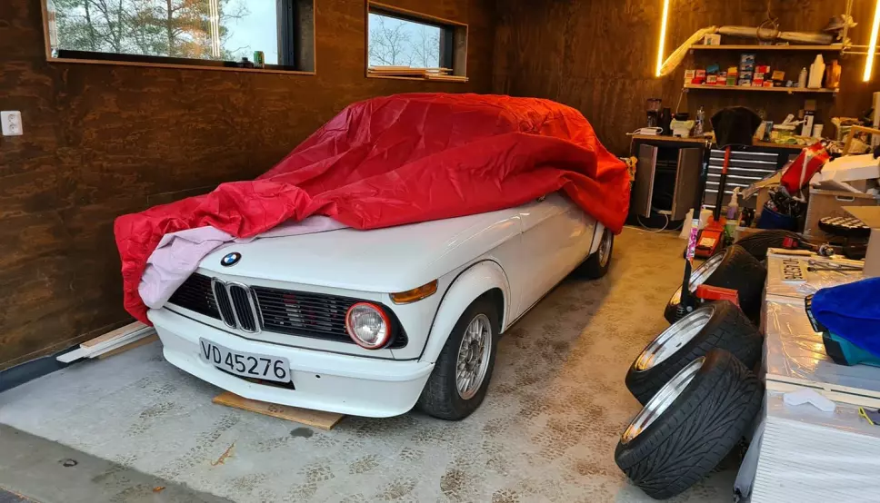 NISSELUE: Christian Røren kommer i julestemning med rød lue på «nissen på låven», eller garasjen. Hans BMW 2002 får godt stell hele året, også gjennom høytiden.