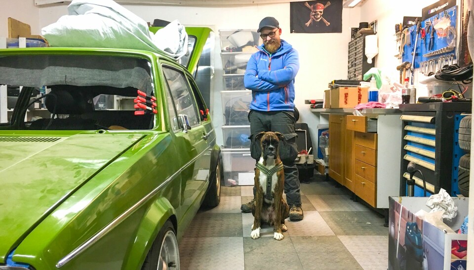 FAMILEMEDLEM: Joachim Næss, hans grønne Golf og boxeren Knirk på en improvisert garasjeplass i en låve forut for familiens flytting. Hunden er dessverre i mellomtiden gått bort.