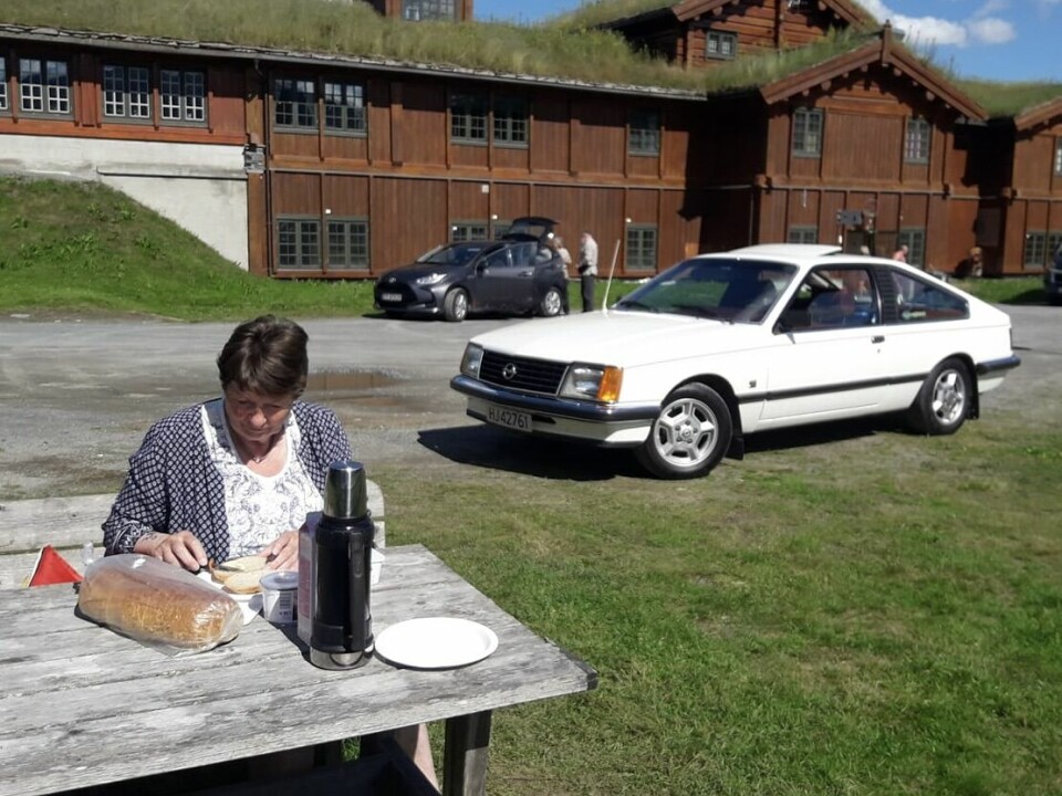 MAT FOR MONZA: Jorunn Wattum forsyner seg av medbrakt proviant mens samboer Jens-Olav Smestad har påtatt seg jobben med å ta bilde av måltidet og parets Opel Monza. Foto: PRIVAT