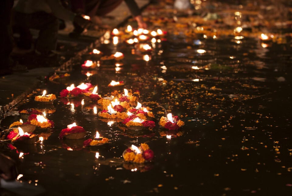 OFFERSEREMONI: Små oljelamper plassert på små båter av blader på Ganges etter solnedgang.